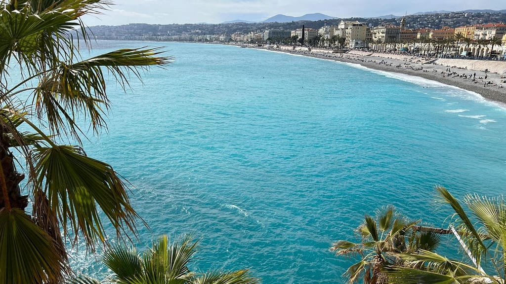 View of the Promenade des Anglais and turquoise coastline in Nice, France — popular family beach destination.