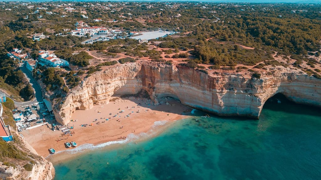 Aerial view of Praia da Marinha in the Algarve, Portugal, with clear turquoise water and golden cliff coastline.