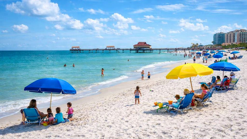 Clearwater Beach Florida with soft white sand, calm turquoise water, and Pier 60 in the background