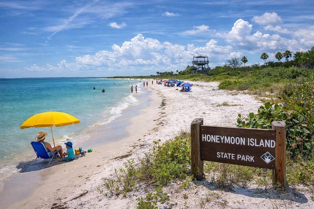 honeymoon-island-beach-florida-family-travel-1200x800 | Go With The Family Honeymoon Island State Park beach in Florida with calm water and families relaxing under umbrellas