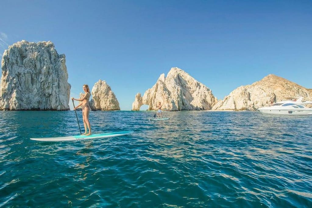 Families enjoying calm turquoise water in Puerto Vallartas Banderas Balos-cabos-arch-el-arco-beach-1200x800 | Go With The Family El Arco rock formation in Los Cabos with turquoise water and paddleboarder
