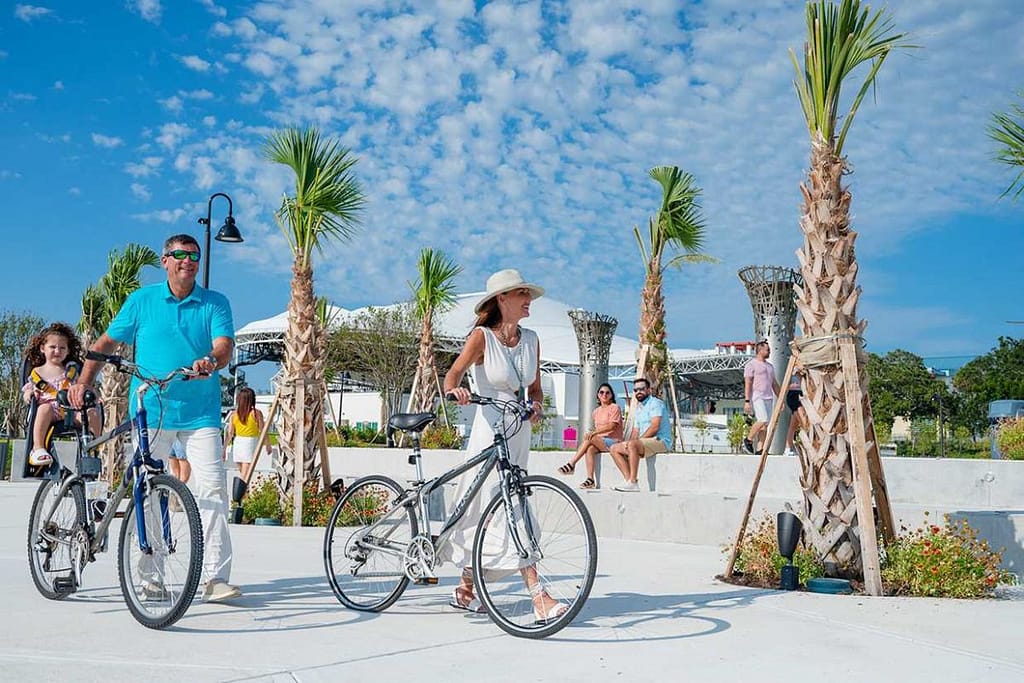 clearwater-beach-promenade-family-biking-1200x800 | Go With The Family Families biking and walking along Clearwater Beach promenade with palm trees and ocean views