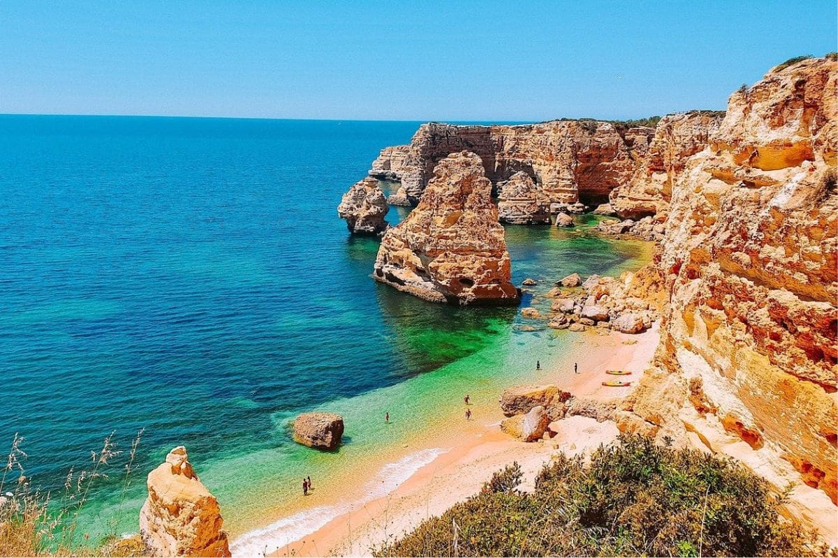 algarve-family-friendly-beach-portugal | Go With The Family Golden cliffs and turquoise water along the Algarve coast near Lagos, Portugal, with a family-friendly beach below.