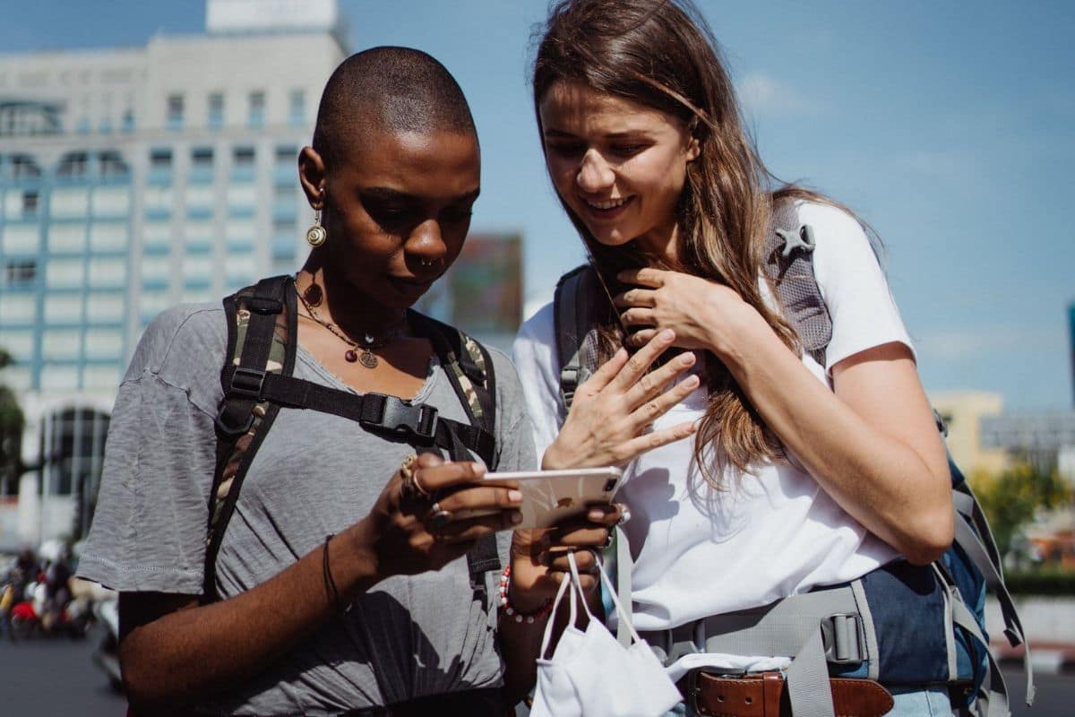 family-using-disney-planning-app | Go With The Family Family members using a smartphone to plan their Disney World vacation with the My Disney Experience app.
