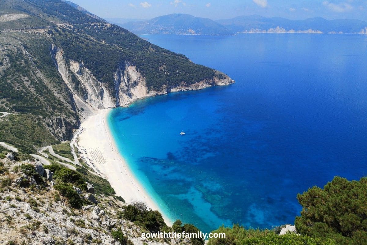 kefalonia-family-beaches-greece.j | Go With The Family Panoramic view of Myrtos Beach in Kefalonia, Greece, with turquoise water, white cliffs, and a scenic coastline.