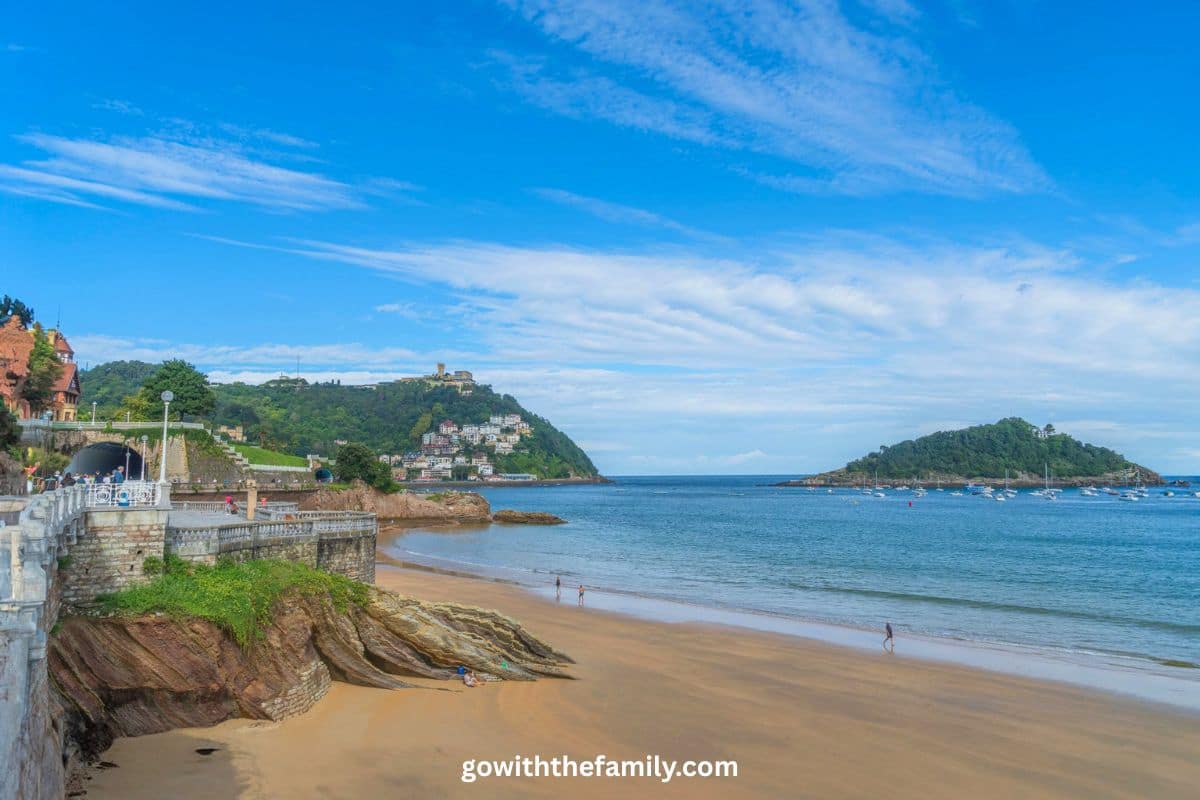 northern-spain-family-beaches-san-sebastian | Go With The Family La Concha Beach in San Sebastián, Northern Spain, with sandy shoreline and green hills