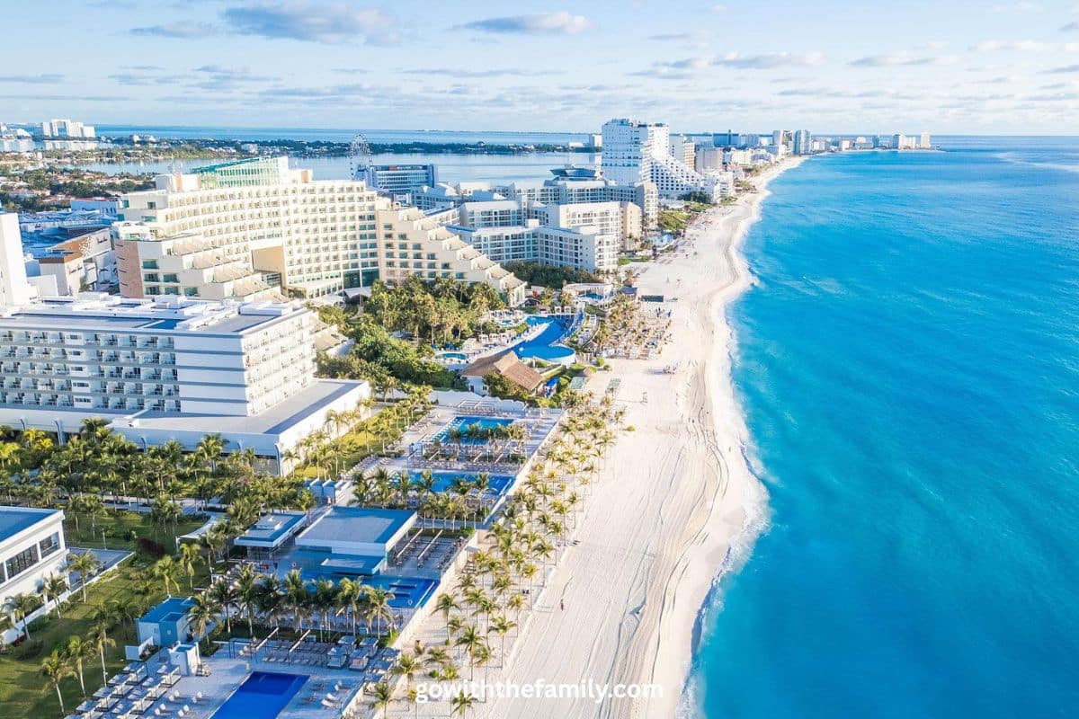 Cancun Hotel Zone Family Beach Aerial View | Go With The Family Aerial view of Cancun Hotel Zone with white sand beach, turquoise water, and beachfront family-friendly resorts in Mexico