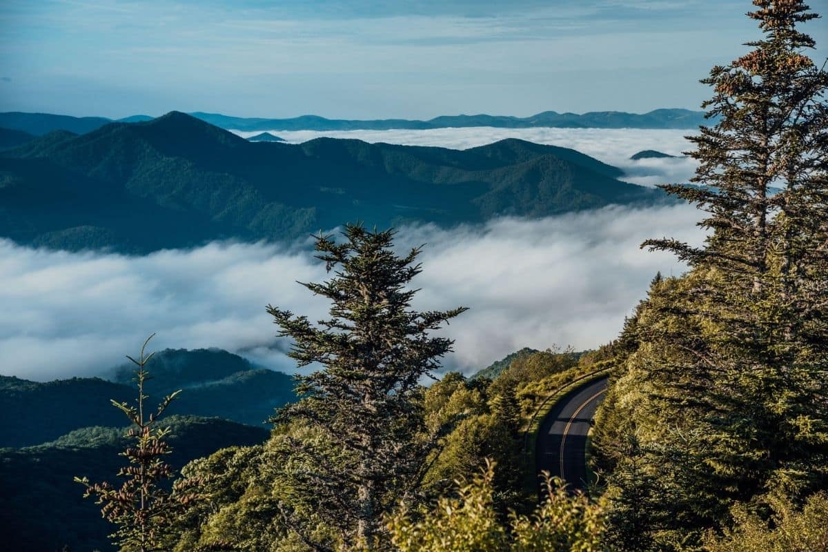 Blue Ridge Parkway Mountain Overlook | Go With The Family Blue Ridge Parkway winding through layered mountain ridges and low clouds in North Carolina