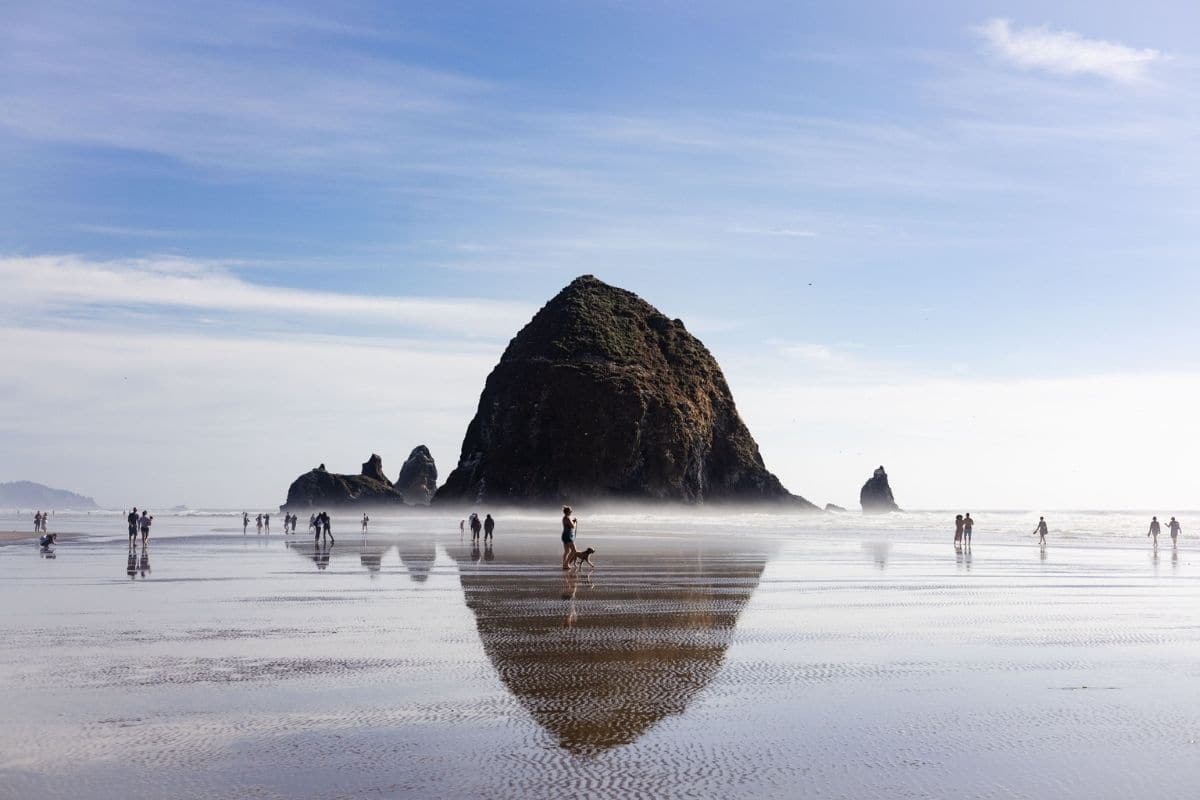 Cannon Beach & Haystack Rock — Oregon Coast | Go With The Family Haystack Rock reflected on the beach at low tide in Cannon Beach, Oregon