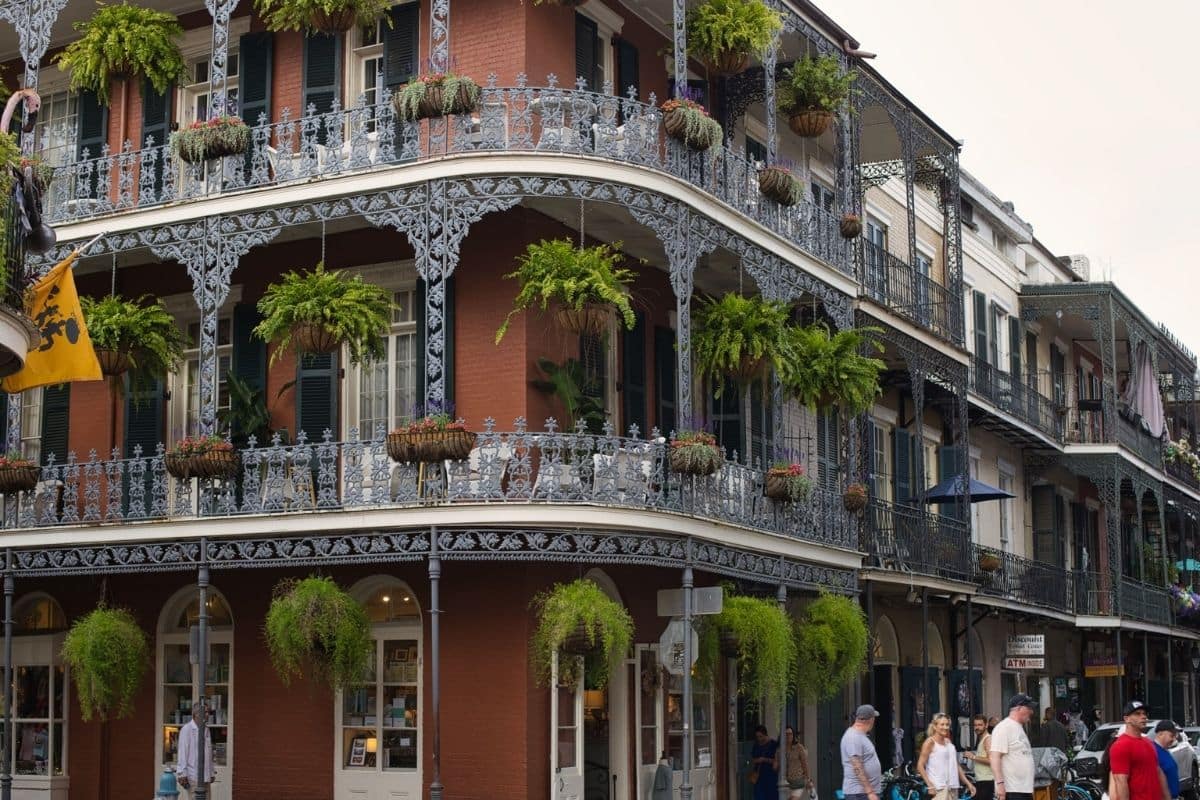 French Quarter Architecture in New Orleans | Go With The Family Historic French Quarter buildings with cast-iron balconies and hanging ferns in New Orleans