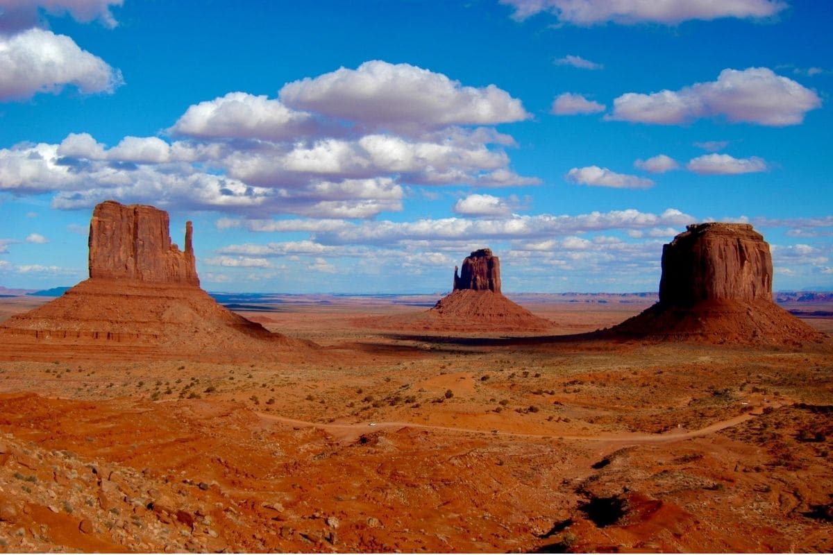 The Mittens — Monument Valley Navajo Tribal Park | Go With The Family East and West Mitten Buttes and Merrick Butte rising above the desert in Monument Valley Navajo Tribal Park