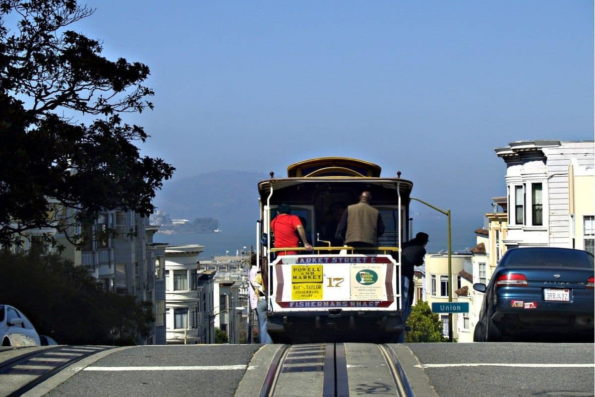 San Francisco Cable Car on a Steep City Street | Go With The Family San Francisco cable car travelling down a steep city street toward the bay