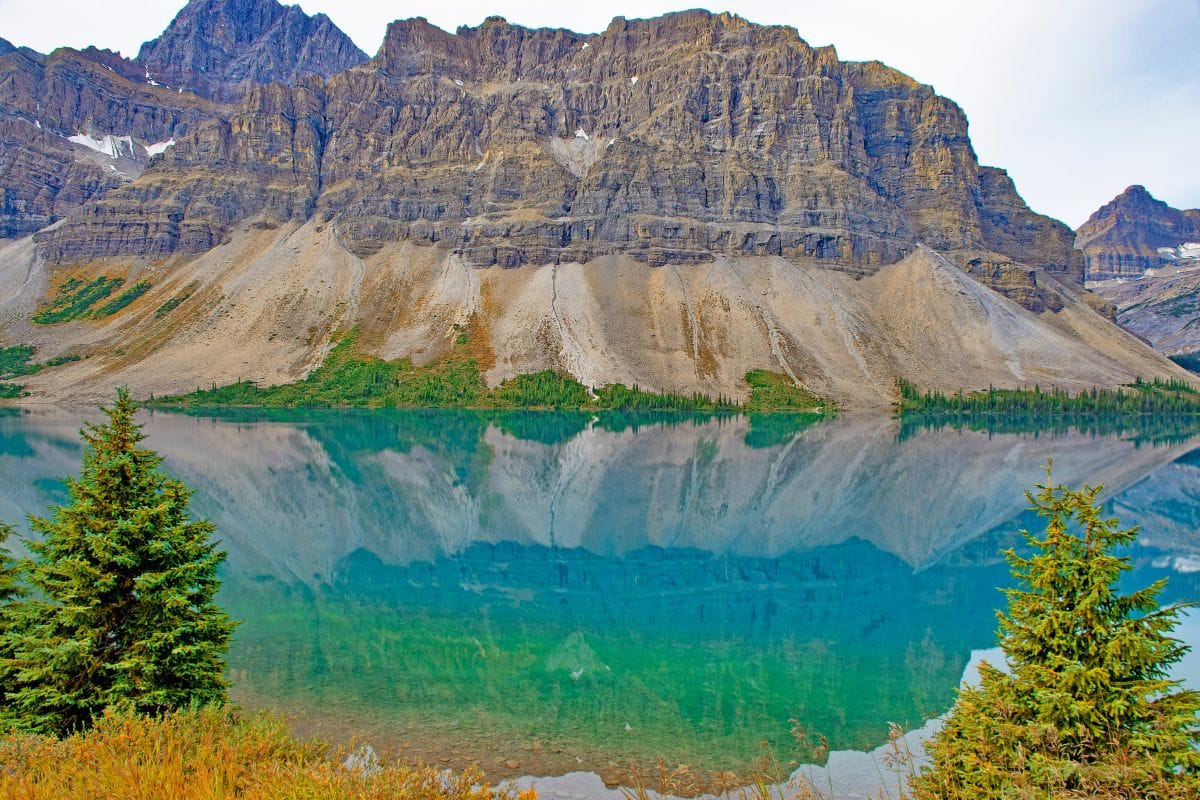 Bow Lake Reflections on the Icefields Parkway | Go With The Family Mountain peaks reflected in turquoise Bow Lake along the Icefields Parkway in Banff National Park, Alberta