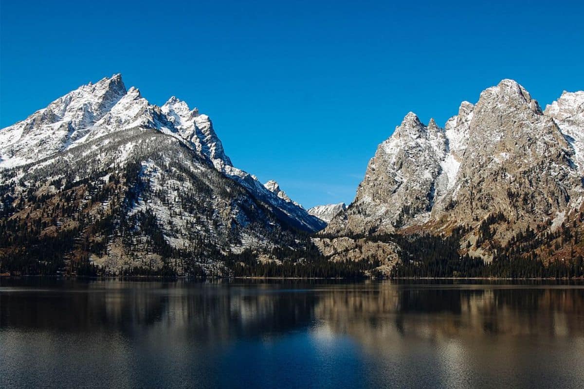 Jenny Lake and the Teton Range | Go With The Family Jenny Lake reflecting the snow-covered Teton Range in Grand Teton National Park