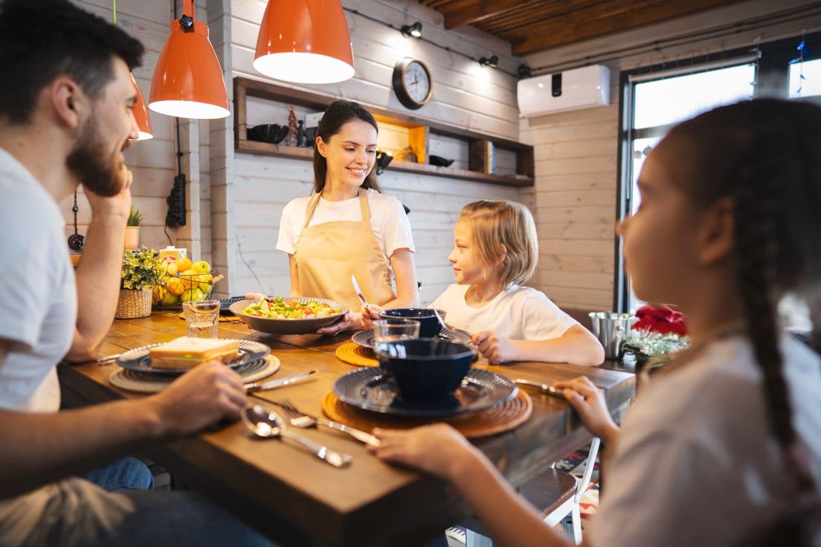 Family Enjoying a Budget-Friendly Meal Together | Go With The Family Family sitting together at home planning a trip, looking at a map and smiling.
